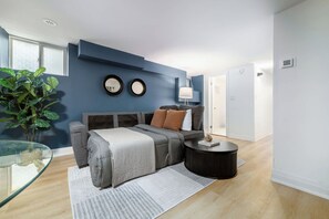 A modern living room with a sectional sofa, a glass coffee table, and a side table with a lamp.