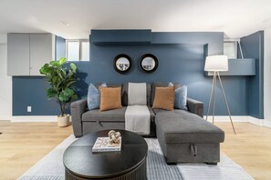 A modern living room with a sectional sofa, a coffee table, and a floor lamp.