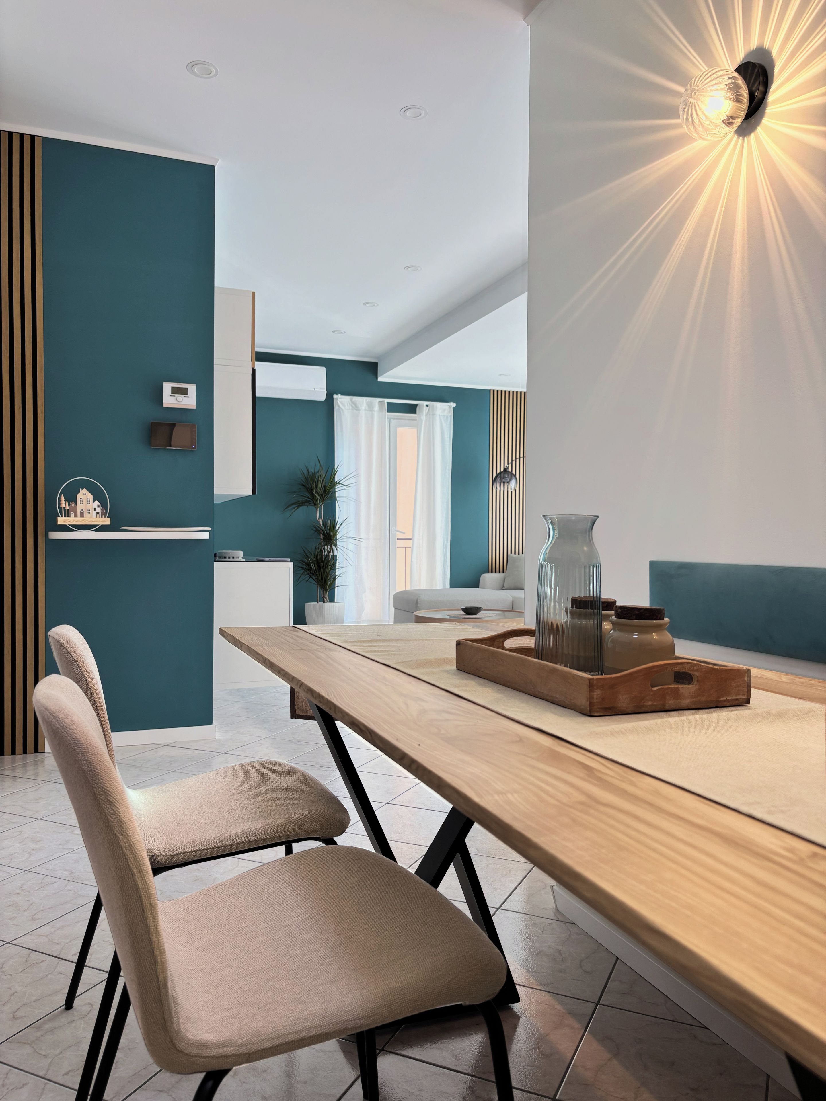 Una zona pranzo moderna con un tavolo in legno, due sedie e un vassoio decorativo.