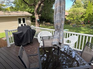 A deck with outdoor furniture, a covered grill, and a view of the backyard. - EAA Gem! Minutes away from the AirVenture grounds. (Oshkosh)