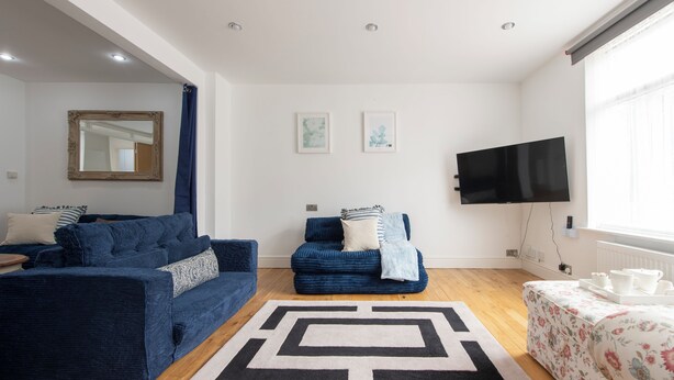 A modern living room with a sofa set, a coffee table, a TV, and artwork on the wall. - Blue Becontree in Goresbrook Village, London (Dagenham)