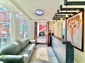 A reception area with a sofa, a reception desk, and a mural of an elephant. - Pulukisi Residence (Kathmandu)