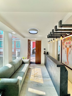 Un interior moderno con un sofá, una recepción y vistas al exterior.