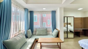 A hotel room with a sofa, a wooden table, and a bed. - Pulukisi Residence (Kathmandu)