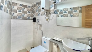 A bathroom with a toilet, bidet, and sink, featuring patterned tiles and a mirror. - Pulukisi Residence (Kathmandu)