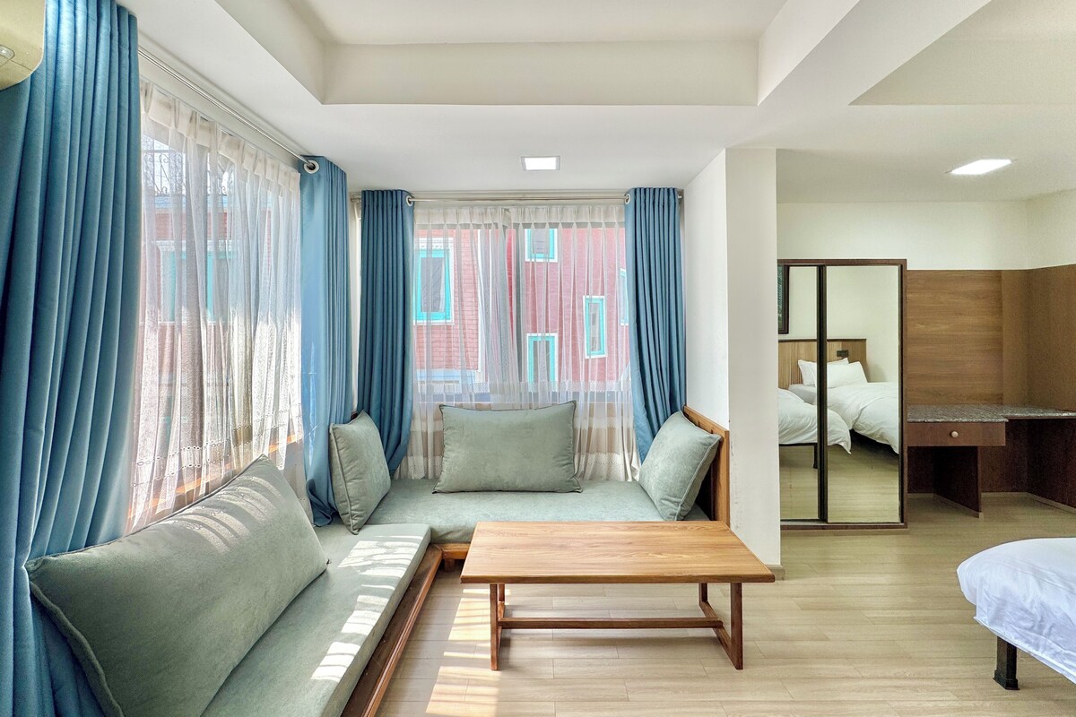Una habitación de hotel con sofá, una mesa de madera y una cama.
