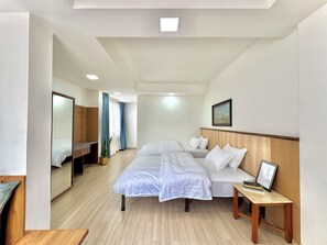 A hotel room with a large bed, a bedside table, a mirror, and a painting on the wall. - Pulukisi Residence (Kathmandu)