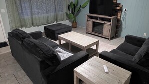 A living room with a sofa set, a coffee table, a TV stand, and a ceiling fan. - Lovely 4-bedroom house in Flagstaff perfect for your getaway (Flagstaff)