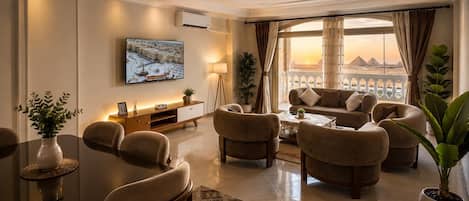A modern living room with a sofa set, a coffee table, and a TV mounted on the wall.