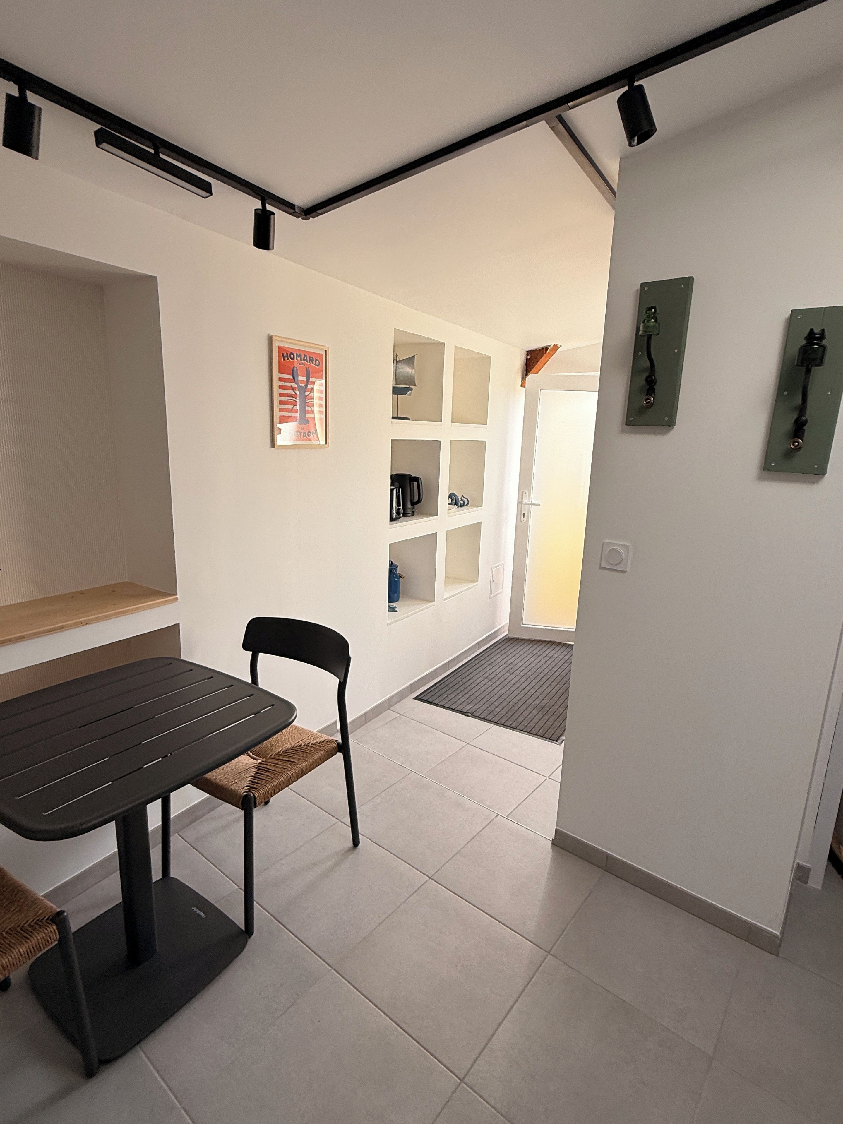 A modern kitchen with a dining table, chairs, and a coffee machine.