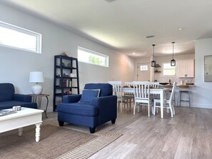 A modern living room with a blue sofa, a white coffee table, and a bookshelf. - Close to Beaches ~ Downtown Venice ~ Bike Trail ~ Park (Nokomis)