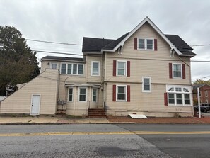 Ein zweistöckiges Haus mit Veranda, Garage und Auffahrt.