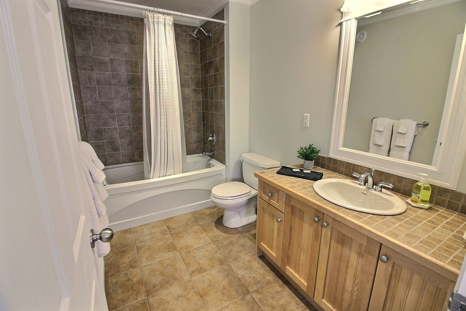 Ein Badezimmer mit Badewanne, Toilette, Waschtisch und Spiegel.