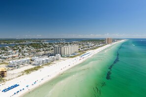 A coastal cityscape with a long sandy beach, a marina, and high-rise buildings. - Beach Views-Private Pool-Central PCB (Panama City Beach)