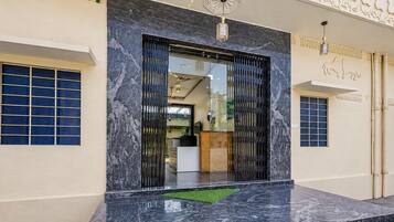 A building entrance with a marble floor, a glass door, and a decorative ceiling.