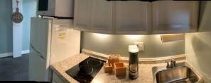 A kitchen with a built-in microwave, a coffee maker, and a sign indicating the apartment number.