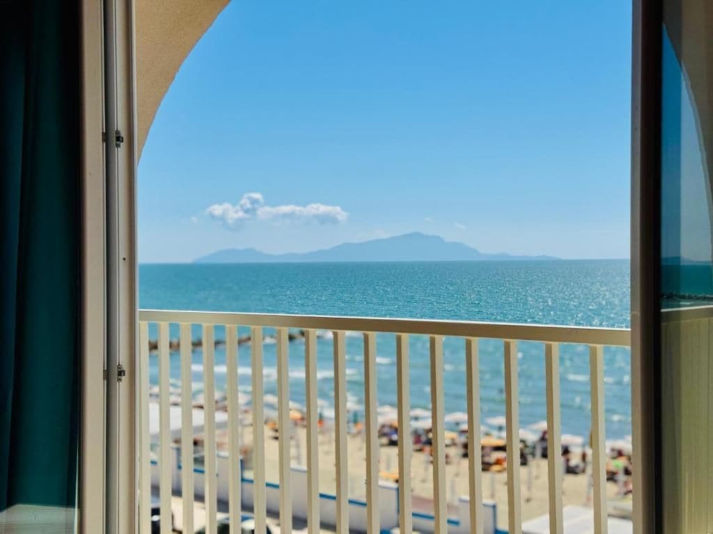 Ein Balkon mit Blick auf Strand und Meer.