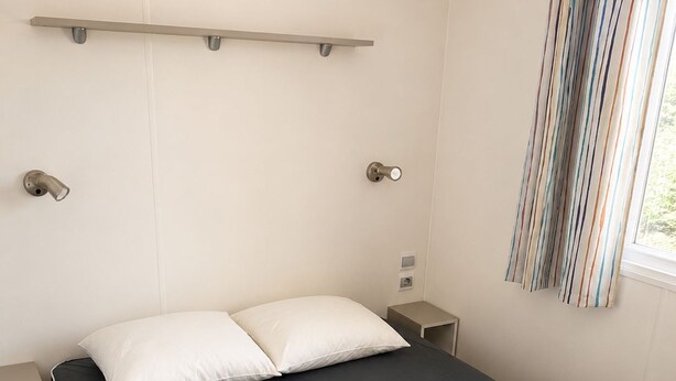 Een slaapkamer met een bed, nachtkastjes, een raam met gordijnen en een wandplank.