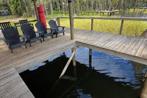A wooden deck with chairs and a small pool. - Lake Santa Fe Getaway | Private Dock + Kayaks (Melrose)