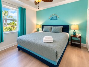 A bedroom with a bed, a nightstand, a lamp, and a wall sign. - Brilliant 1-bedroom apartment with AC in vibrant Orlando (Orlando)