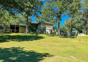 A residential property with a house, a covered porch, and a well-maintained lawn. - Stillwater Cottage at Norfork Lake (Mountain Home)