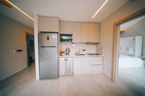 A modern kitchen with a built-in refrigerator, a coffee maker, and a sink.