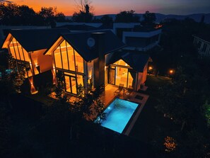 A modern house with large windows and a swimming pool.