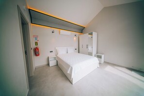 A modern bedroom with a bed, bedside tables, a wardrobe, and a ceiling light fixture.
