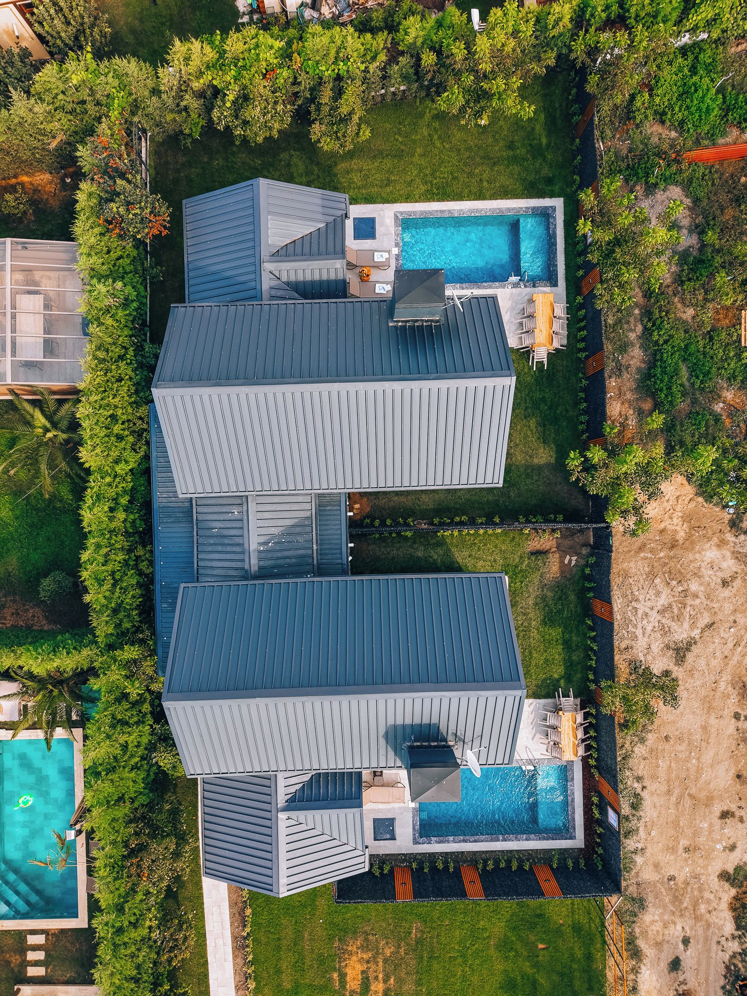 A modern two-story building with a rooftop pool and a covered patio area.