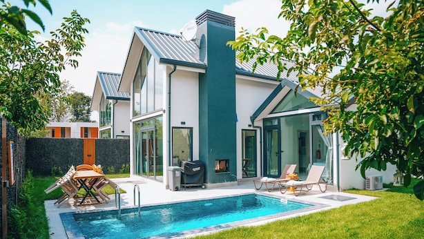 Uma casa moderna com piscina, área de estar ao ar livre e churrasqueira.
