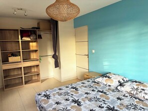 A bedroom with a bed, a wardrobe, and a hanging light fixture. - Creole Villa in a Tropical Garden - 3 Bedrooms & 2 Bathrooms (Sainte-Anne)