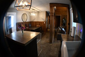 A compact living space with a dining area, a seating area, and a kitchenette. - 5BR All-Sports Lakehouse · Hot Tub + Pontoon · Portage (Portage)