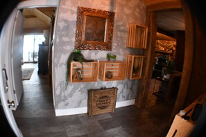 A hallway with a wooden bench, a mirror, and a decorative wooden crate. - 5BR All-Sports Lakehouse · Hot Tub + Pontoon · Portage (Portage)