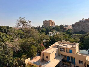 A residential area with multiple buildings, some with satellite dishes, surrounded by dense greenery. - Solé Mare Rooftop Studio I Nesty Hospitality (Al Maadi)