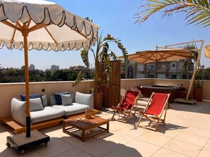 A rooftop terrace with a sofa, two chairs, a table, and a hot tub. - Solé Mare Rooftop Studio I Nesty Hospitality (Al Maadi)