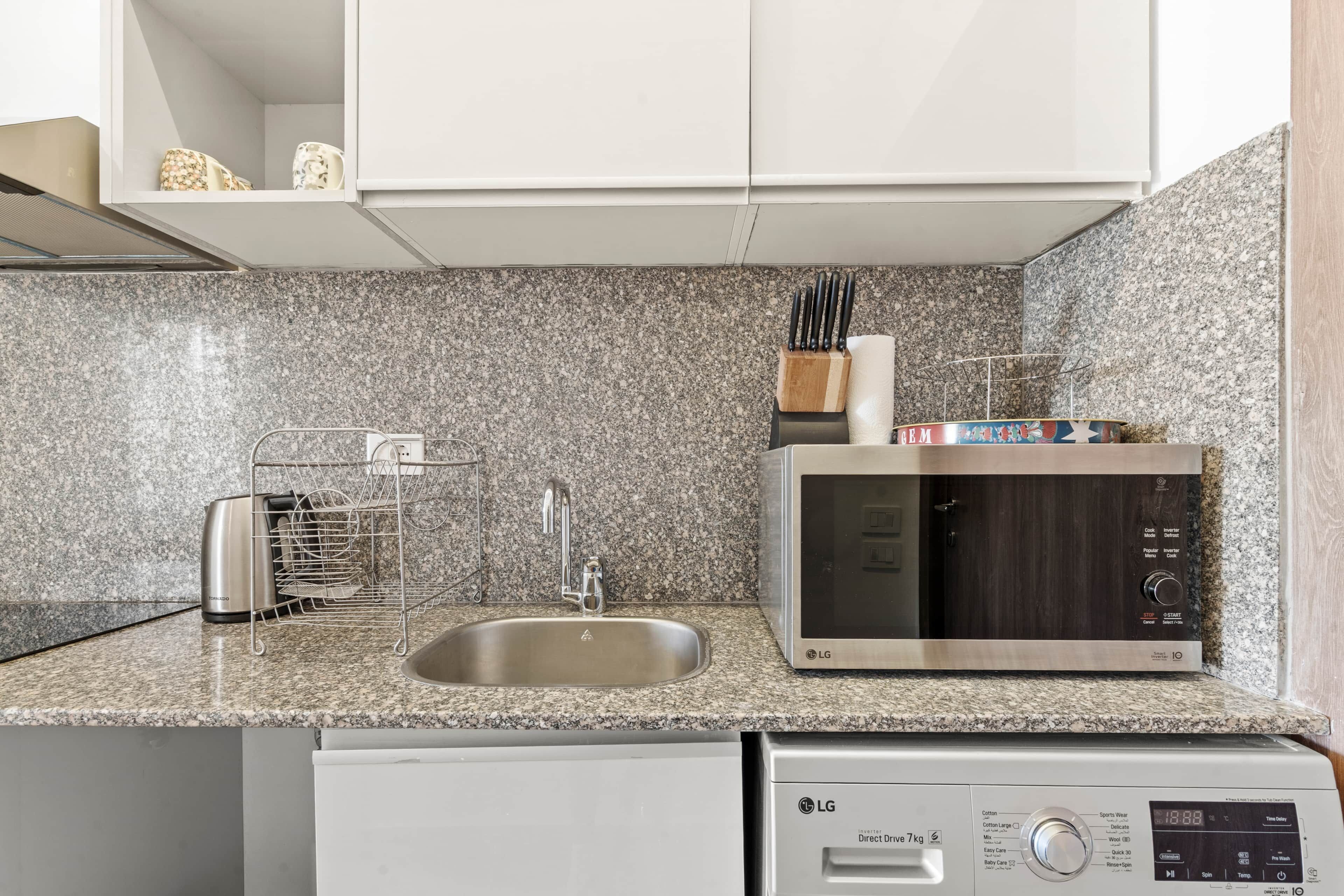 A kitchen with a granite countertop, stainless steel appliances, and a dishwasher.
