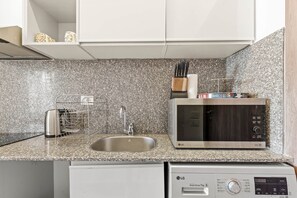 A kitchen with a granite countertop, stainless steel appliances, and a dishwasher. - Maraya Hideaway Private Jacuzzi| Nesty Hospitality (Second Hurghada)