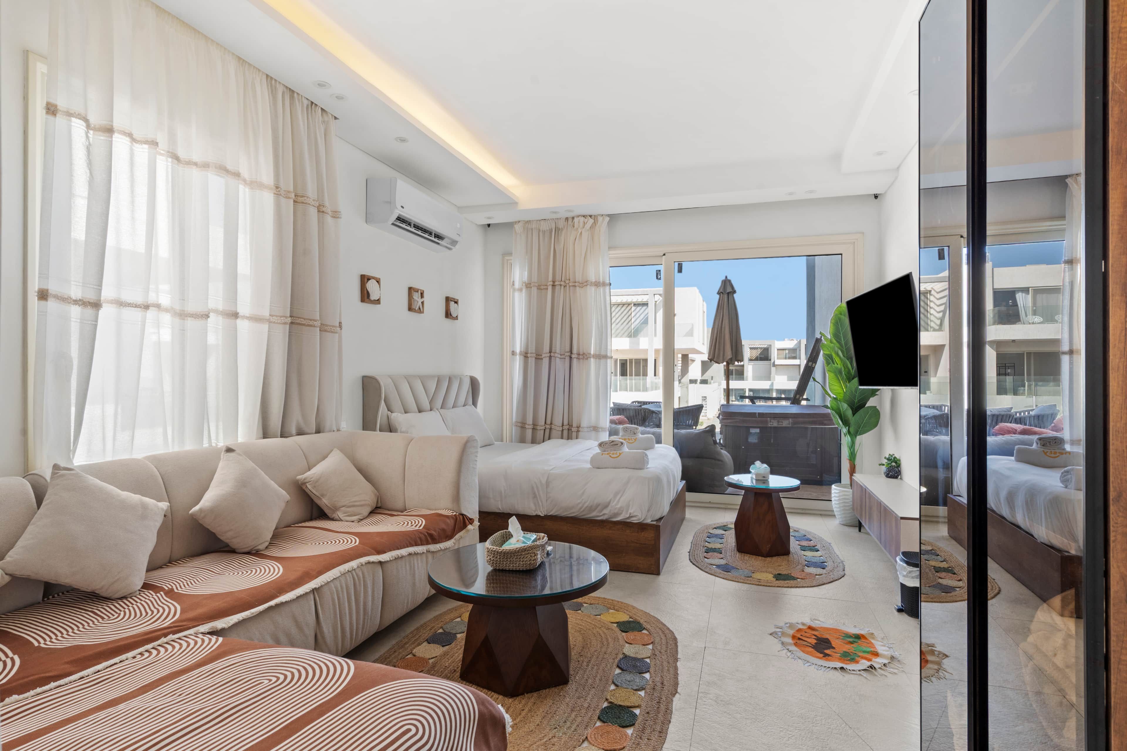 Une chambre d’hôtel avec un canapé, un lit, une petite table et une vue sur la ville.