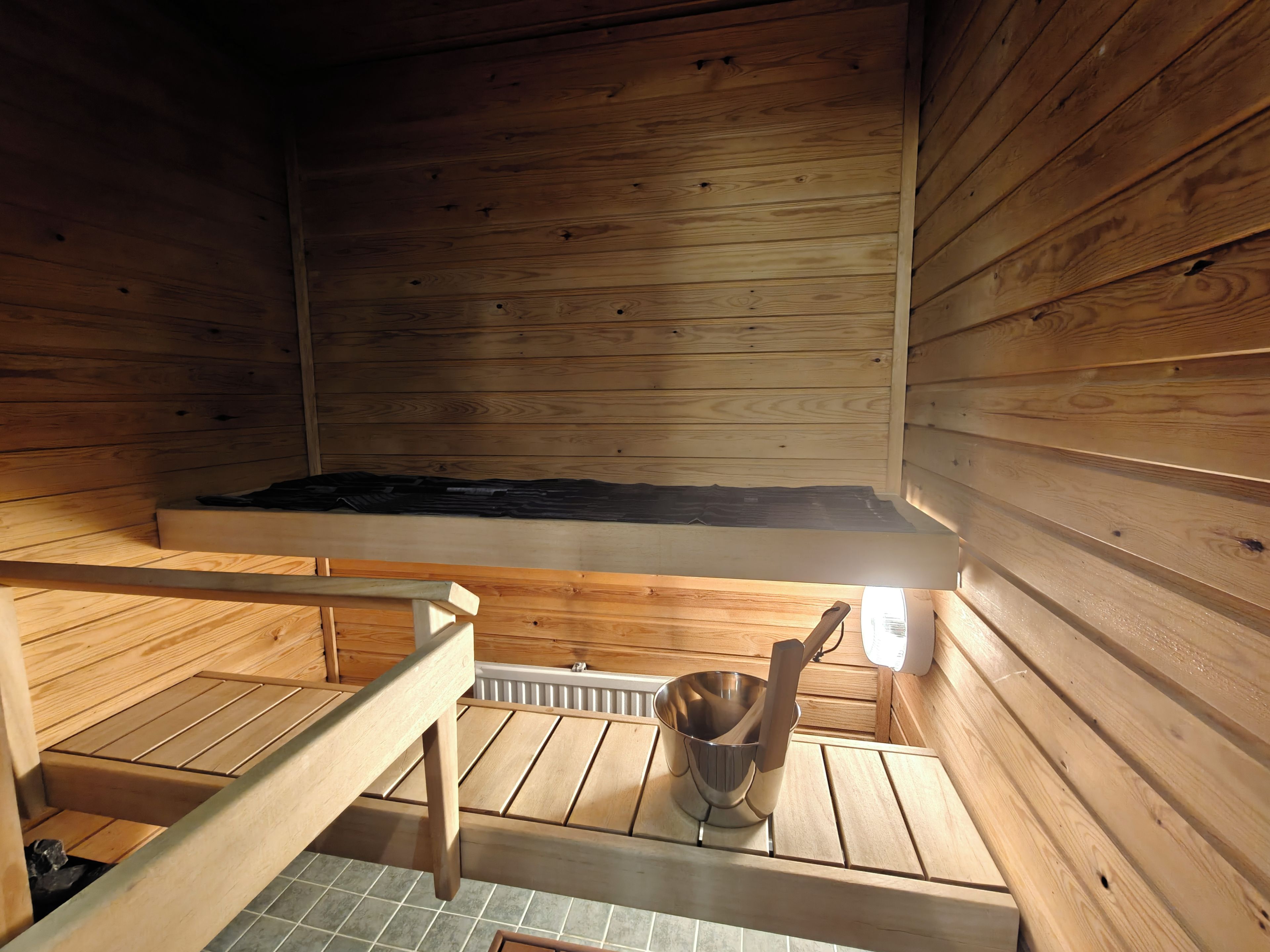 Sauna, jossa on puuseinät ja penkki.