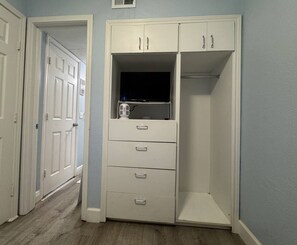 A hallway with a white wardrobe, a door, and a light switch on the wall. - Steps to Beach-Ocean View-1bd1ba- Sleeps 5-Pool (Galveston)