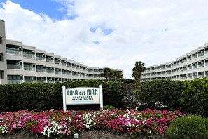 Ein mehrgeschossiges Gebäude mit einem Schild für 'Casa del Mar Beachfront Rental Suites'.