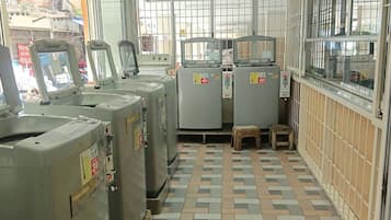 A room with a tiled floor, large industrial machines, and barred windows.