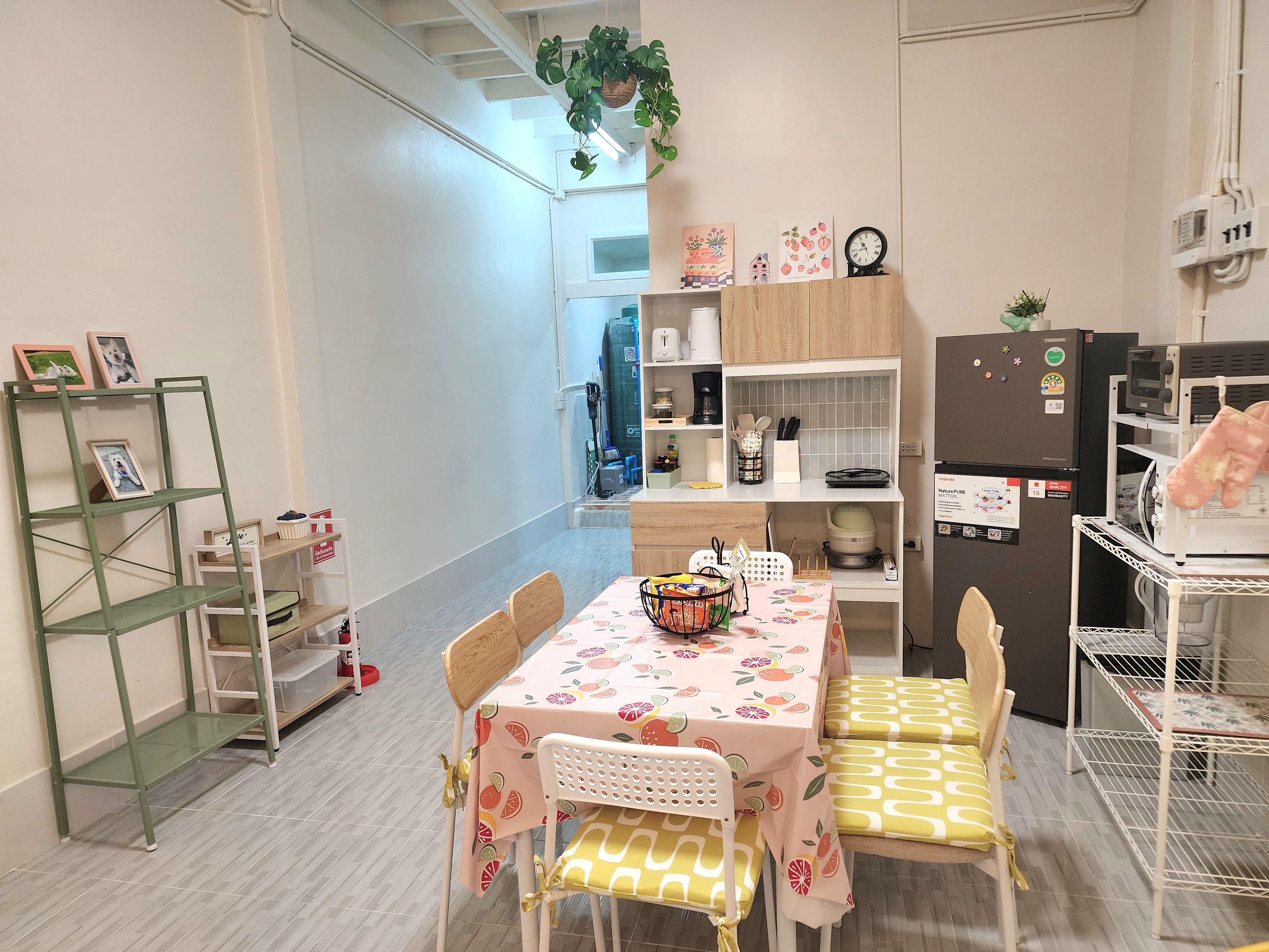 A compact kitchen with a dining table, chairs, and a small refrigerator.