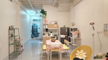 A compact kitchen with a dining area, a water heater, and a refrigerator.