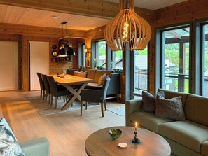 A cozy interior with a dining area, a sofa, and a coffee table with a candle.