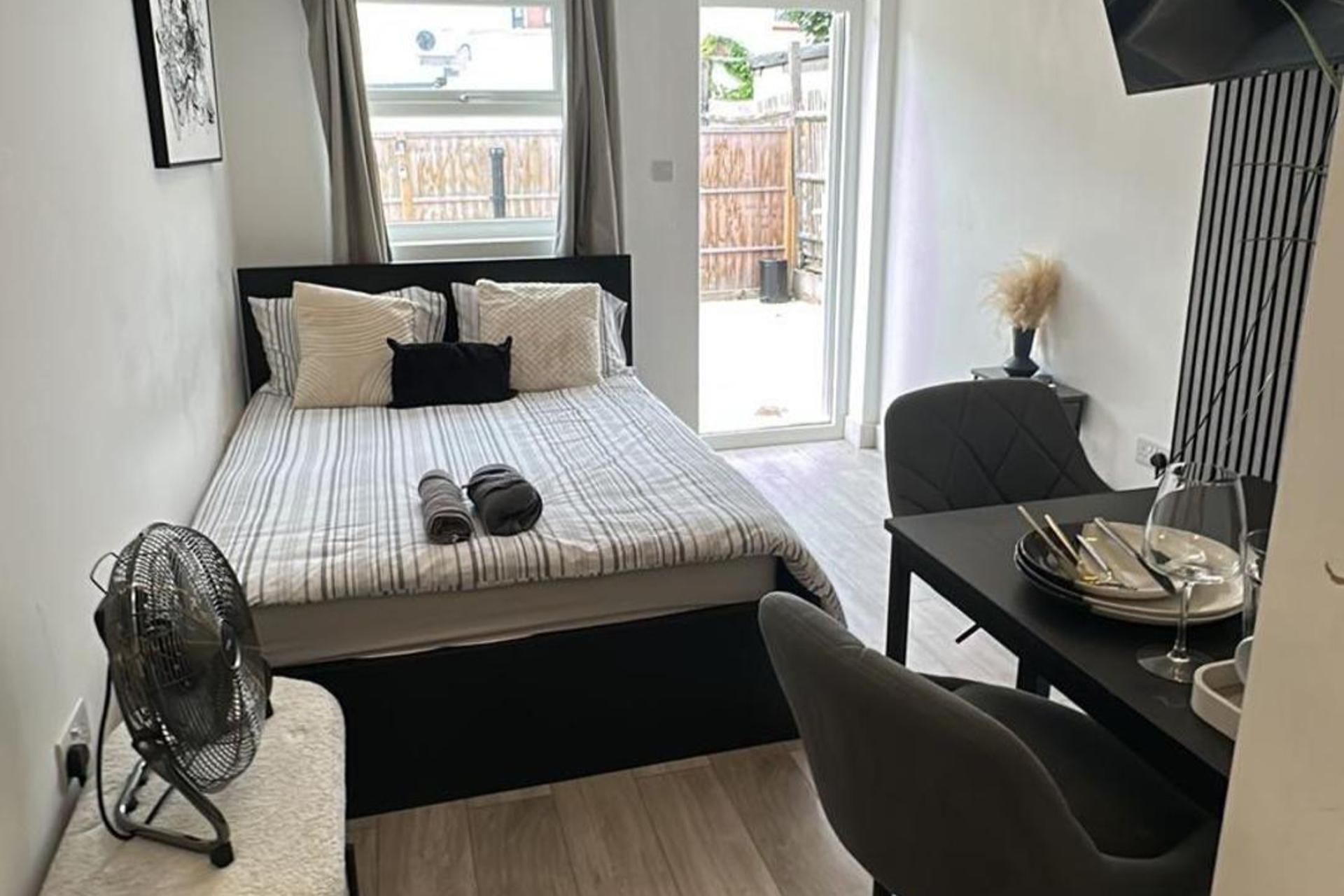 A bedroom with a bed, a desk, and a chair.