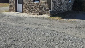 A stone building with a wooden extension, a door, and two windows. - Cozy Home (Bonnemain)