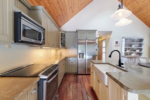A kitchen with a microwave, oven, refrigerator, and water dispenser.