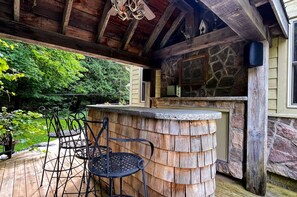 A covered outdoor area with a wooden bar and seating.