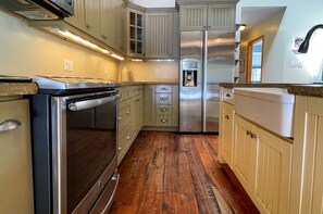 A kitchen with wooden cabinets, a stainless steel refrigerator, and a built-in oven.